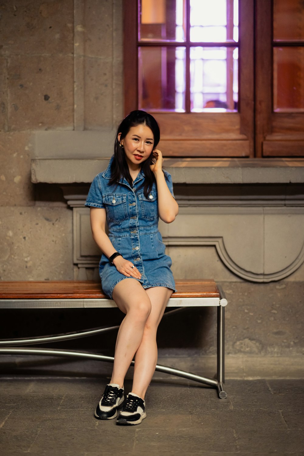 a woman sitting on a bench talking on a cell phone