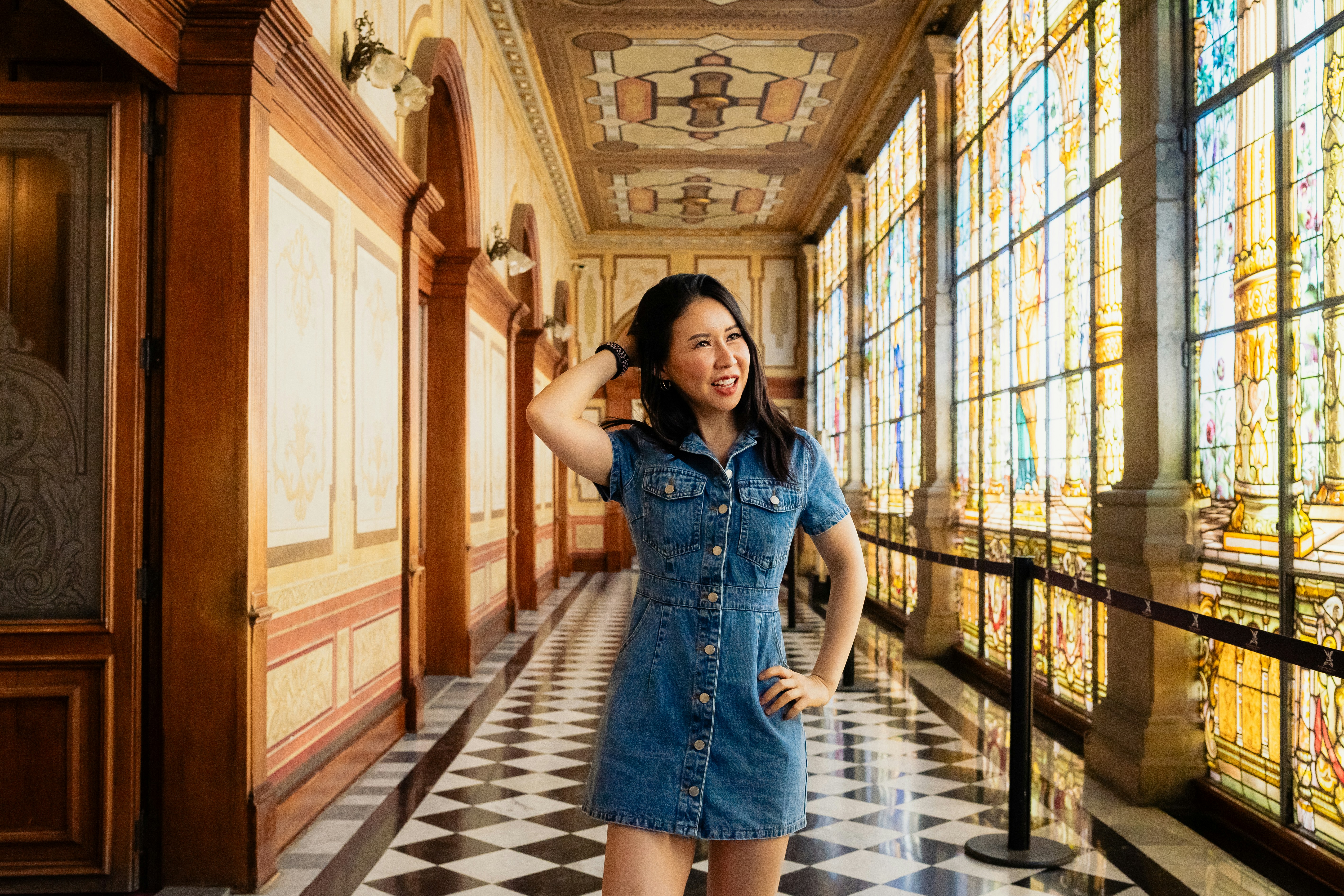 a woman in a denim dress standing in a hallway