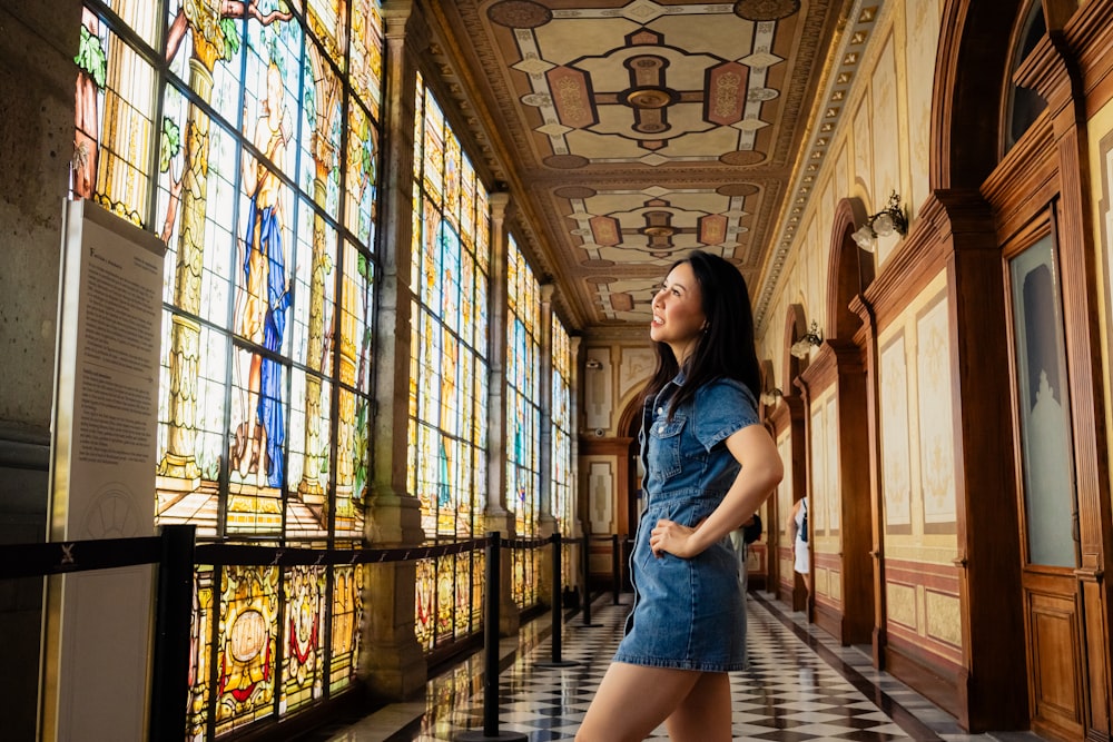 a woman standing in front of stained glass windows