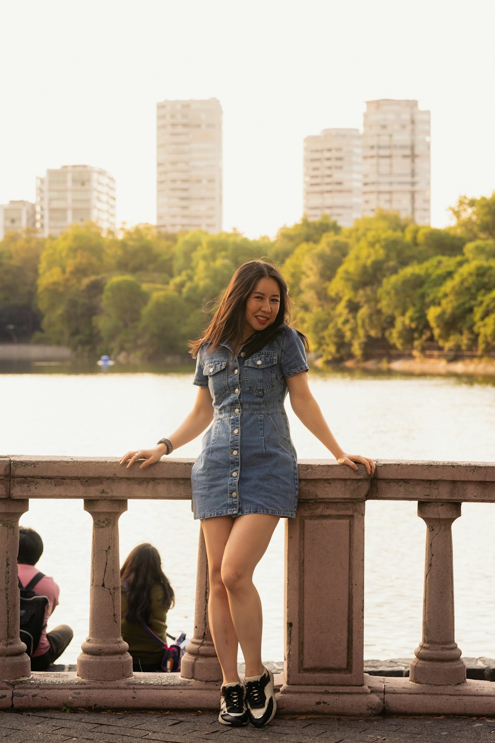 a woman standing on a bridge next to a body of water