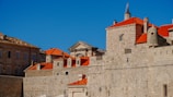 Historic stone buildings of Rijal Alma under a bright blue sky showcasing unique architecture.