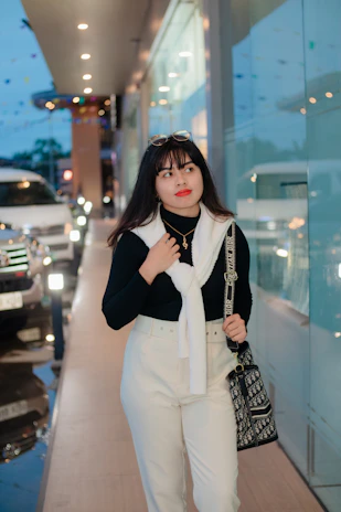 A modern working woman carrying the saarin tote, walking confidently through a softly lit city street.