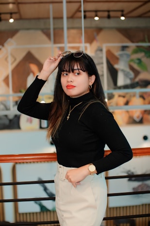 Portrait of a confident woman wearing bold, colorful glasses indoors