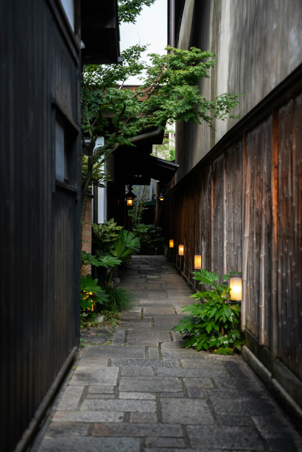 a narrow alley way with a wooden building in the background