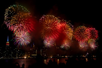 Bright colorful fireworks bursting in the night sky over a cityscape