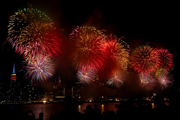 Bright colorful fireworks bursting in the night sky over a cityscape