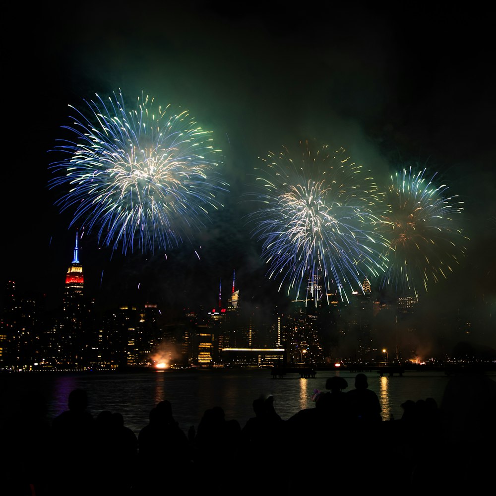 fireworks are lit up the night sky over a city