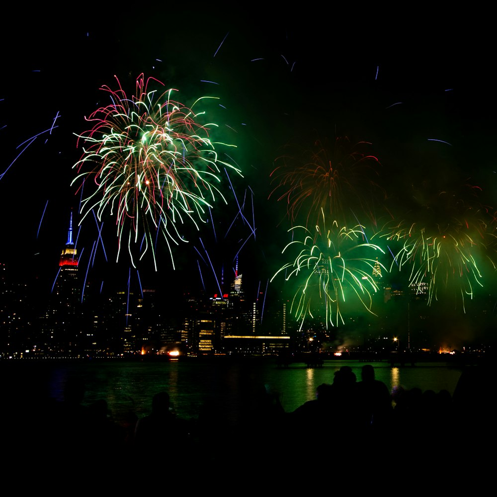 fireworks are lit up in the night sky over a city