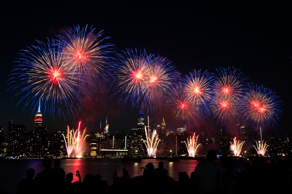 fireworks are lit up the night sky over a city