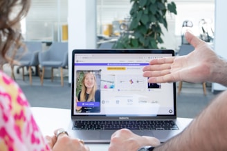 a man and a woman sitting in front of a laptop computer