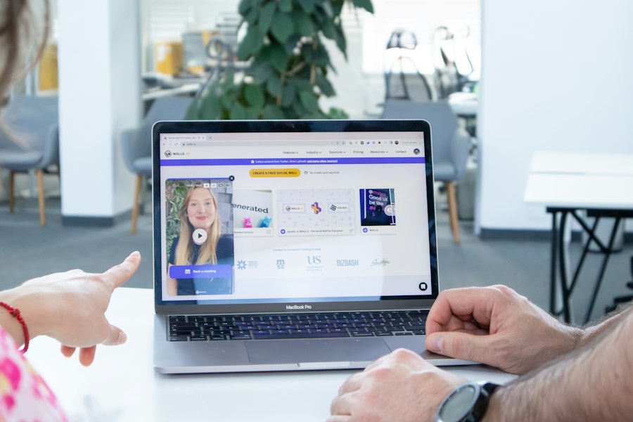 Two people pointing at an online lesson on a laptop