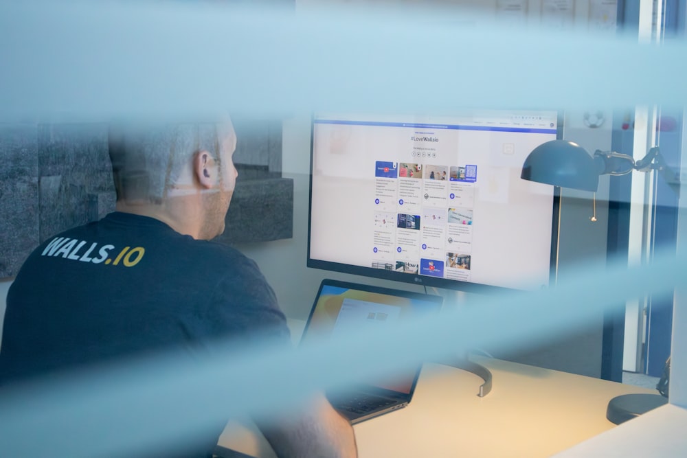 a man sitting in front of a computer monitor