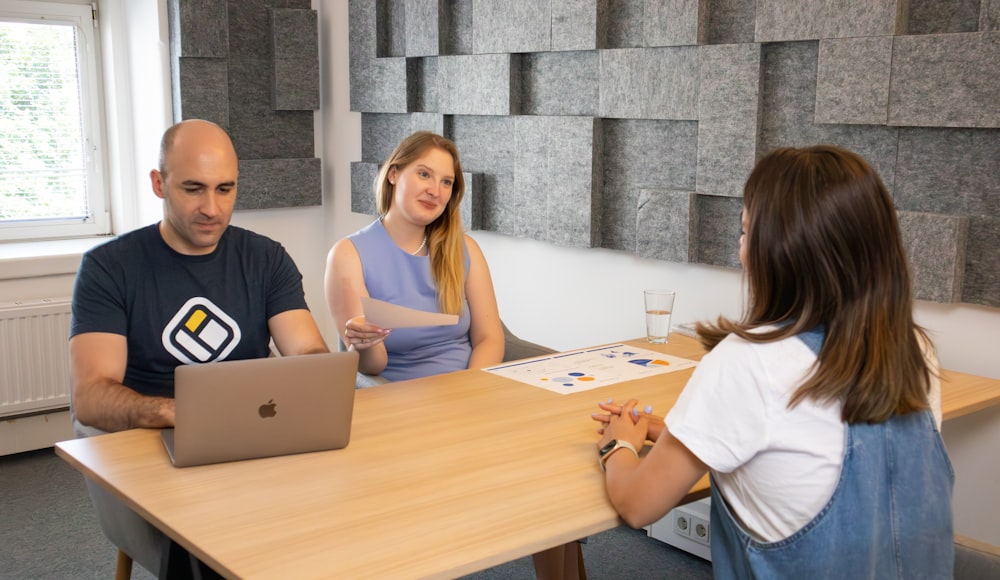 a group of people sitting around a wooden table