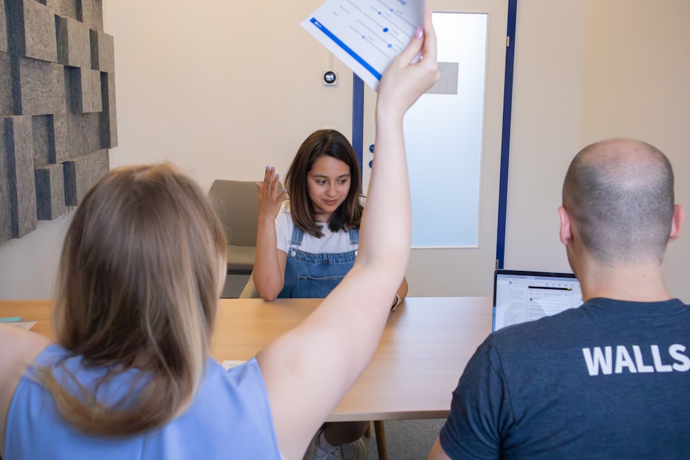 a woman holding up a piece of paper in front of a man