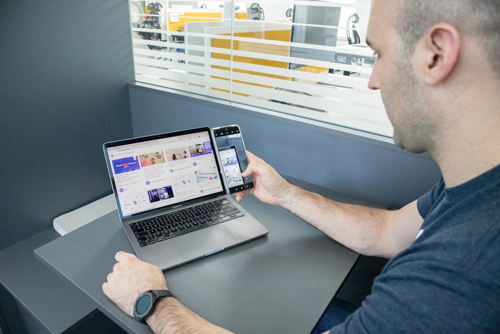 a man sitting at a desk using a laptop computer