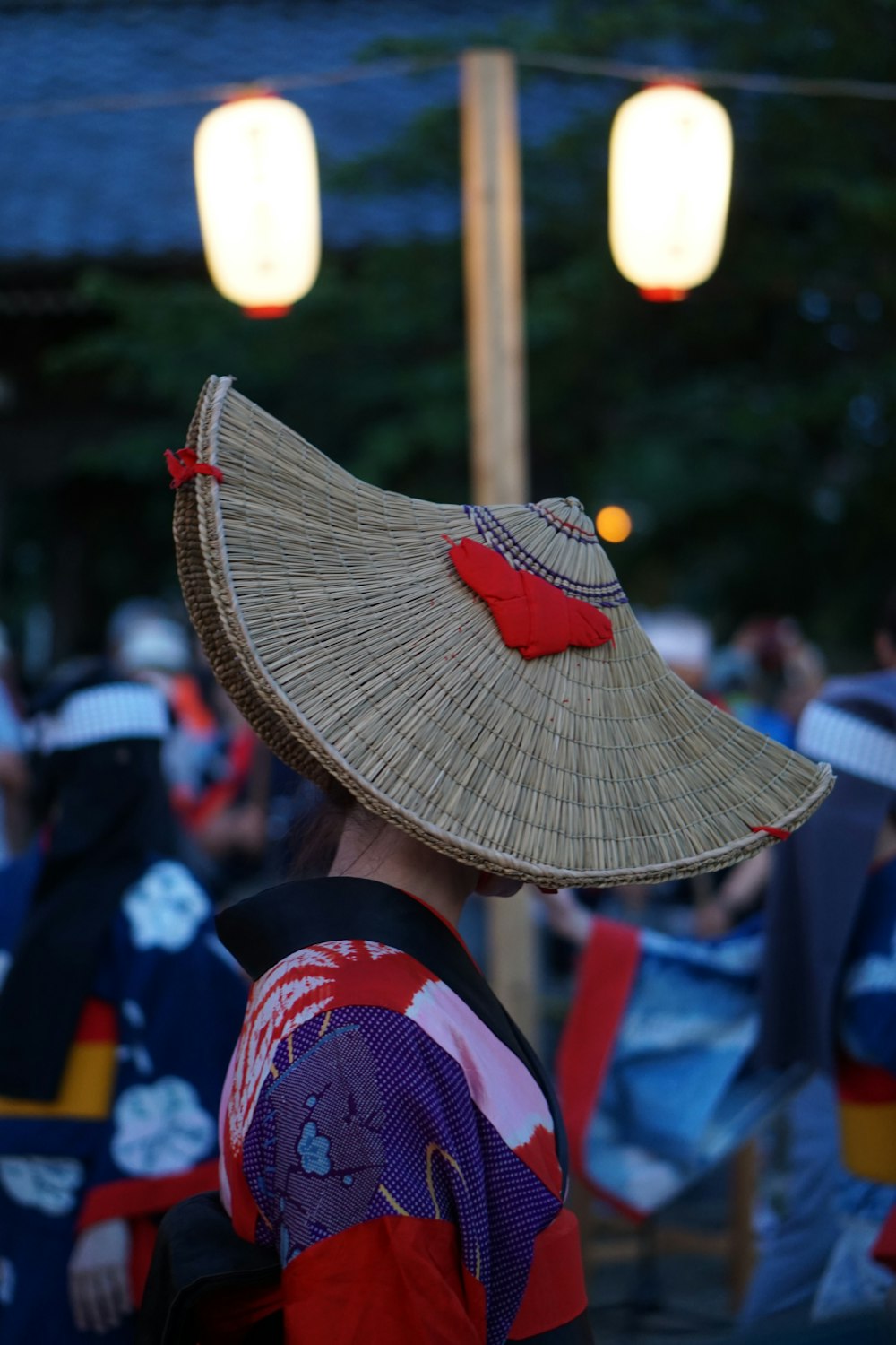 a woman wearing a straw hat with a red bow