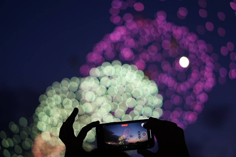 a person taking a picture of a fireworks display