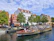 Happy family seated on a cozy canal cruise boat surrounded by historic Amsterdam buildings.