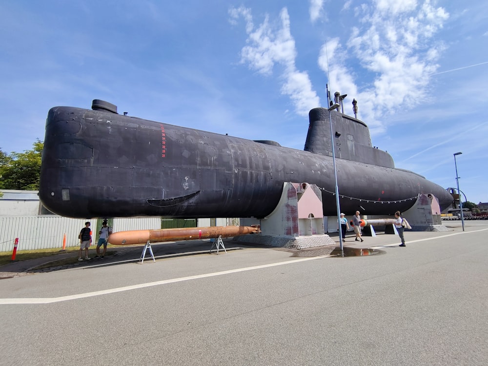 a large black submarine sitting on top of a road