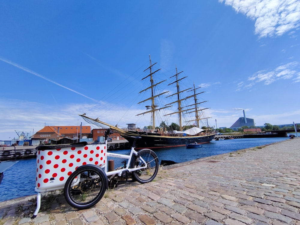 a bicycle parked next to a boat on the water