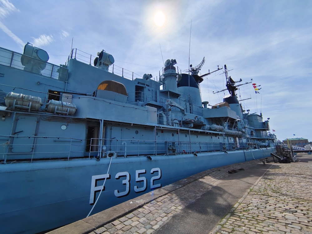 a large blue ship sitting on top of a brick walkway