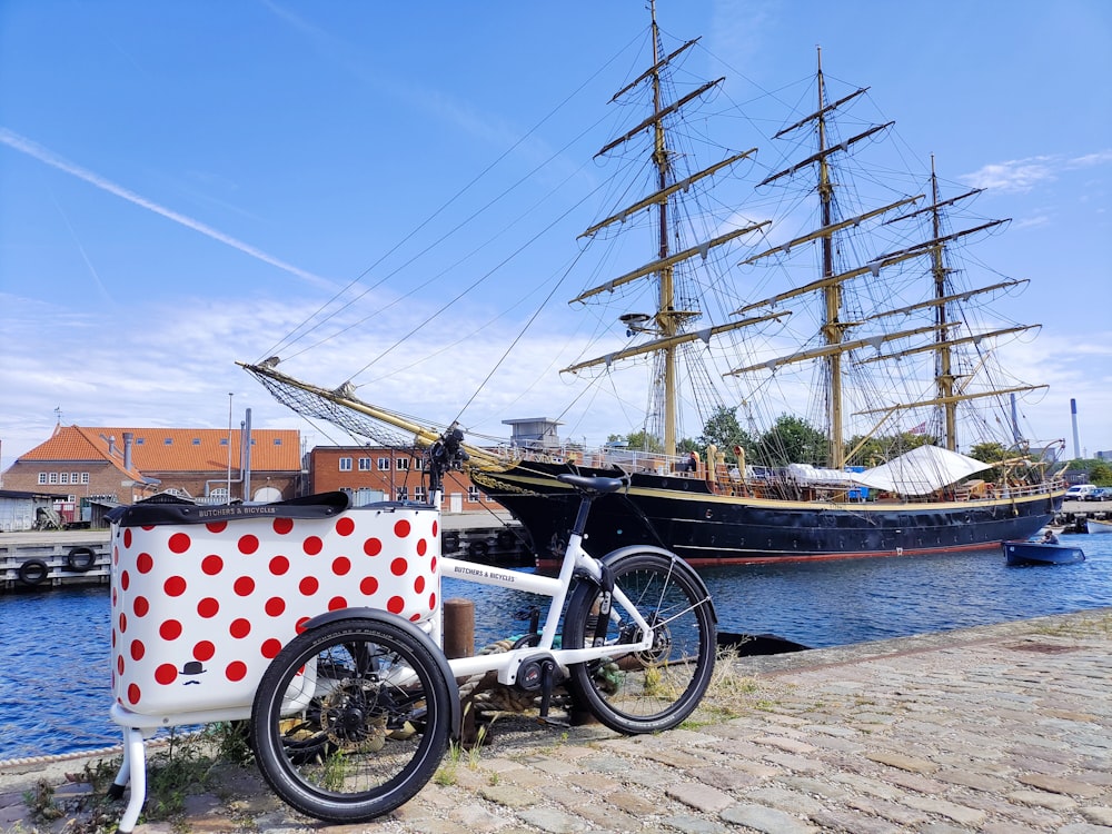 a bicycle parked next to a boat on a body of water