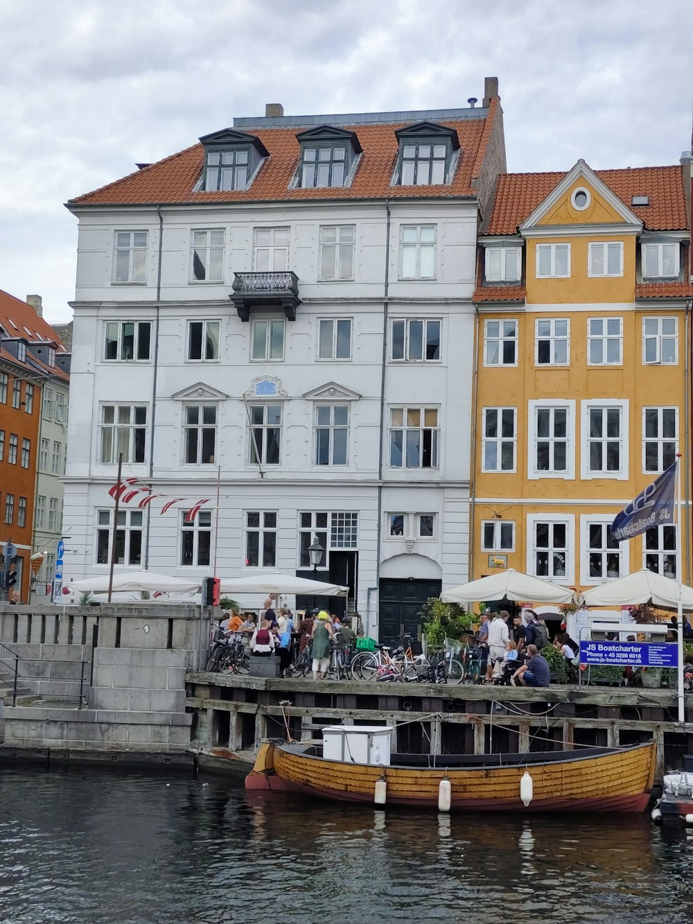 a boat is docked in front of a row of buildings