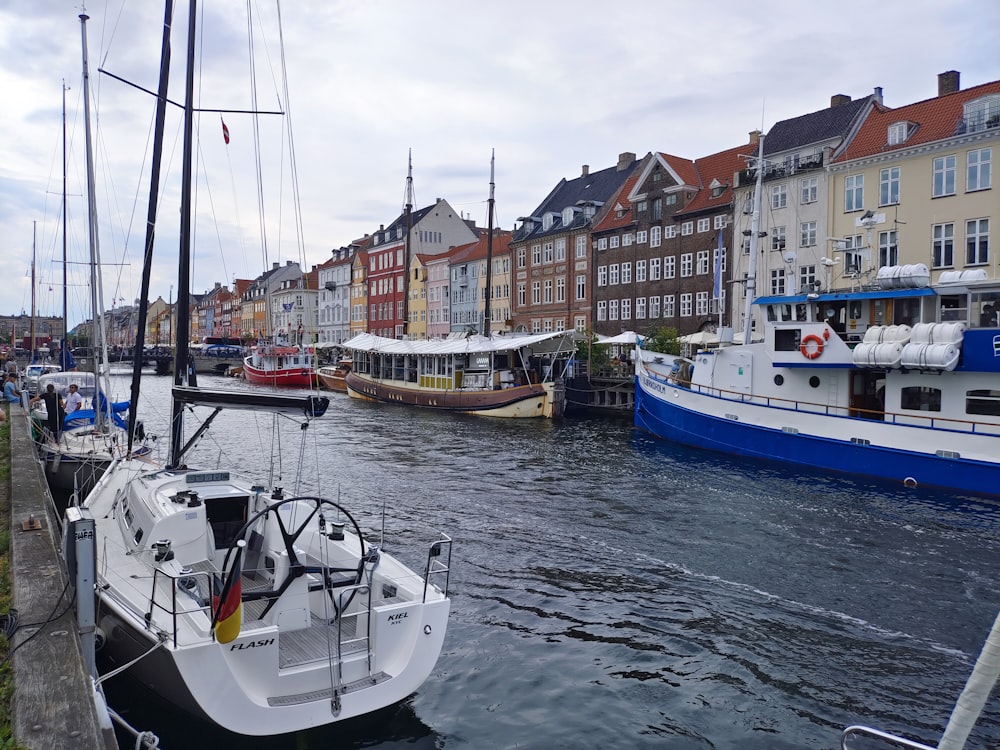 several boats are docked in the water next to buildings