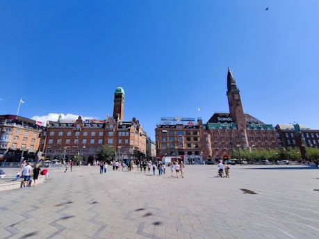a group of people walking around a city square