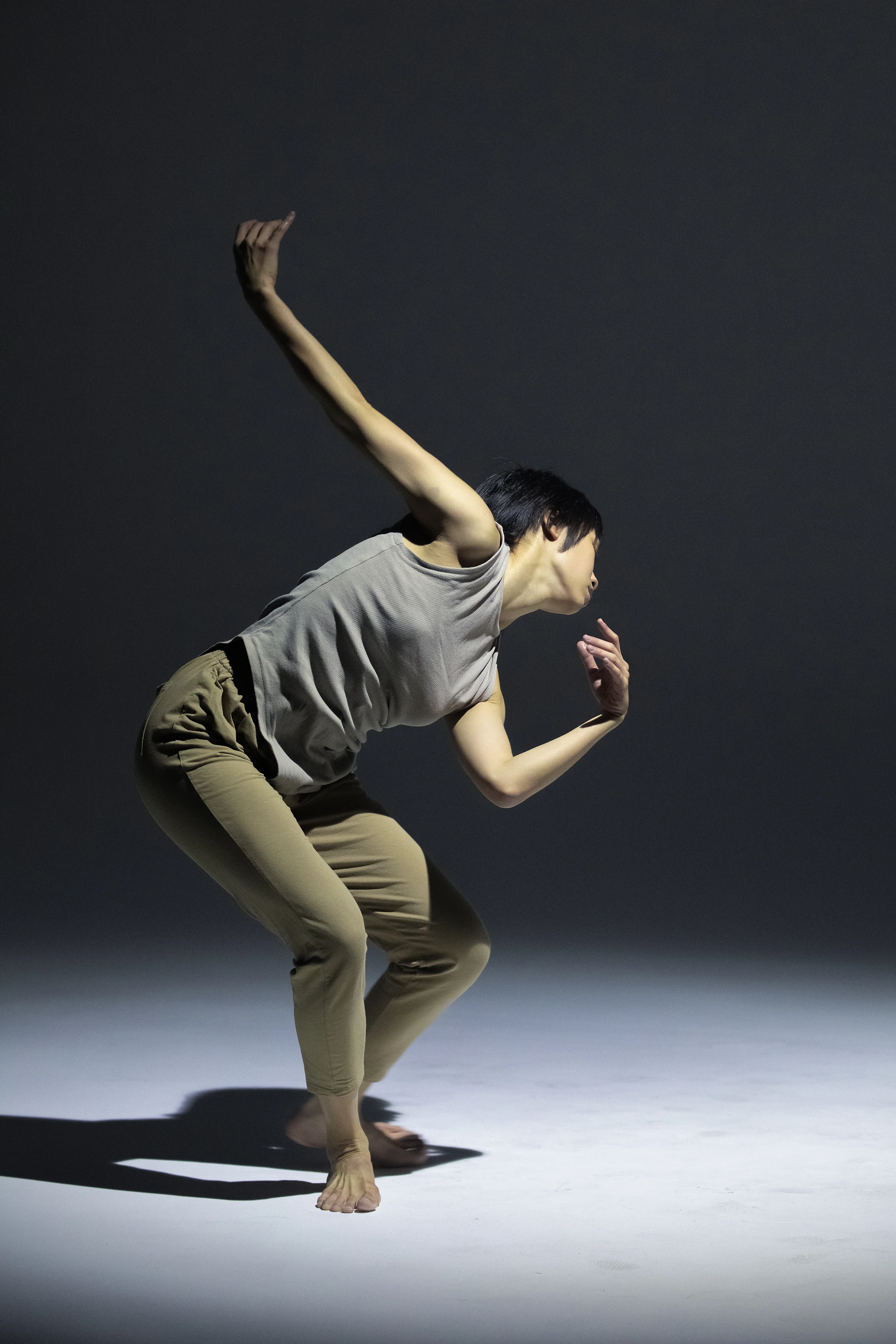A dynamic action shot frozen mid-motion of a dancer captured against a clean studio backdrop.