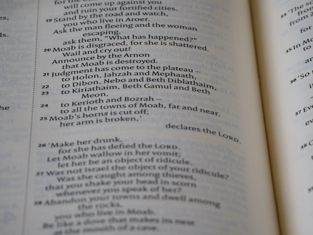 A close-up view of an open book showcasing text in neat, uniform columns. The text is dark against a light-colored page, organized in a structured and easy-to-read manner.