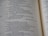 A close-up view of an open book showcasing text in neat, uniform columns. The text is dark against a light-colored page, organized in a structured and easy-to-read manner.