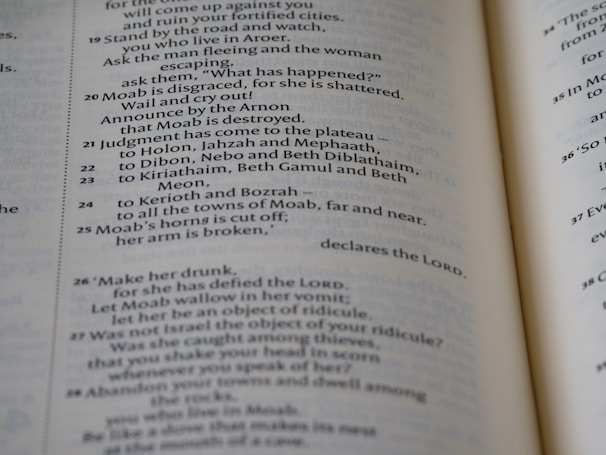 A close-up view of an open book showcasing text in neat, uniform columns. The text is dark against a light-colored page, organized in a structured and easy-to-read manner.