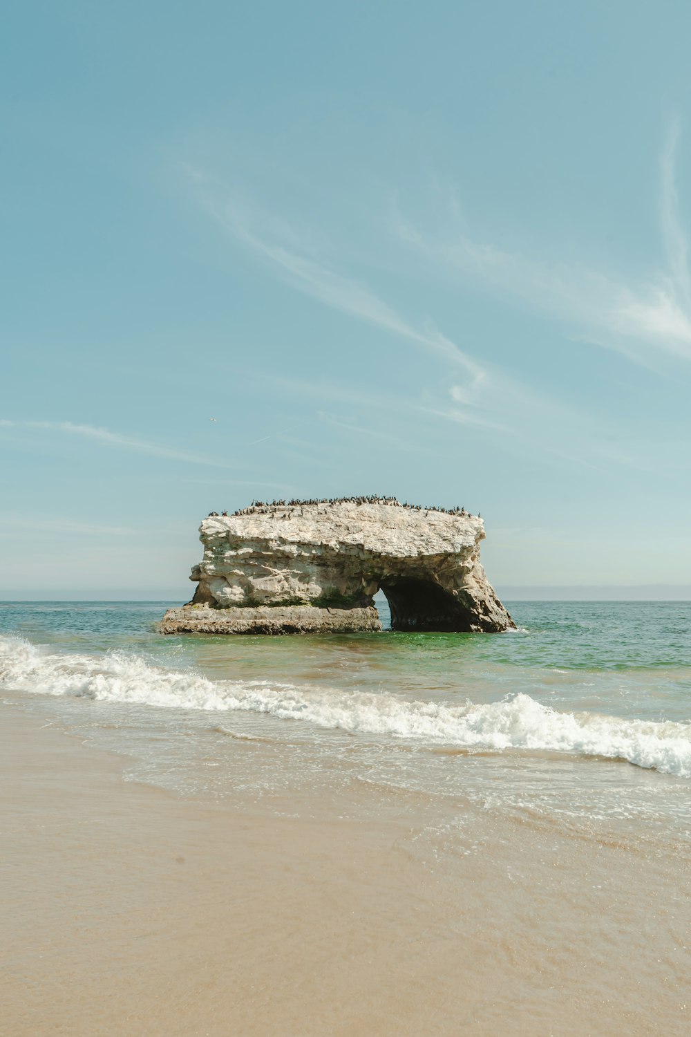 a large rock sticking out of the ocean