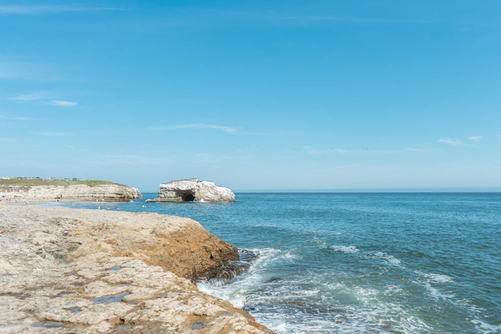 a large body of water sitting next to a rocky shore