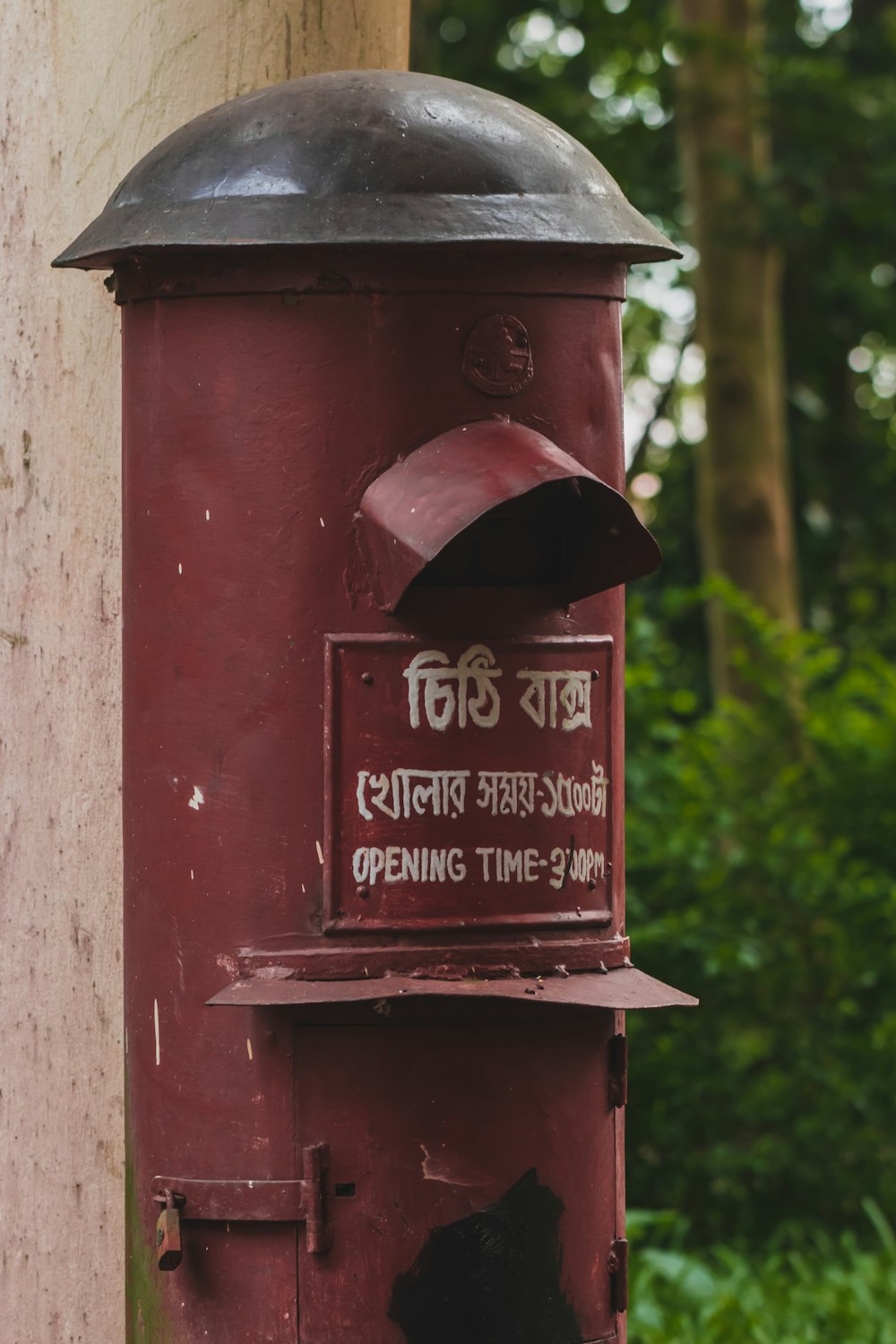 a red mailbox with a sign on it