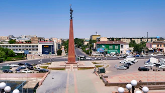 a city square with a tall obelisk in the middle