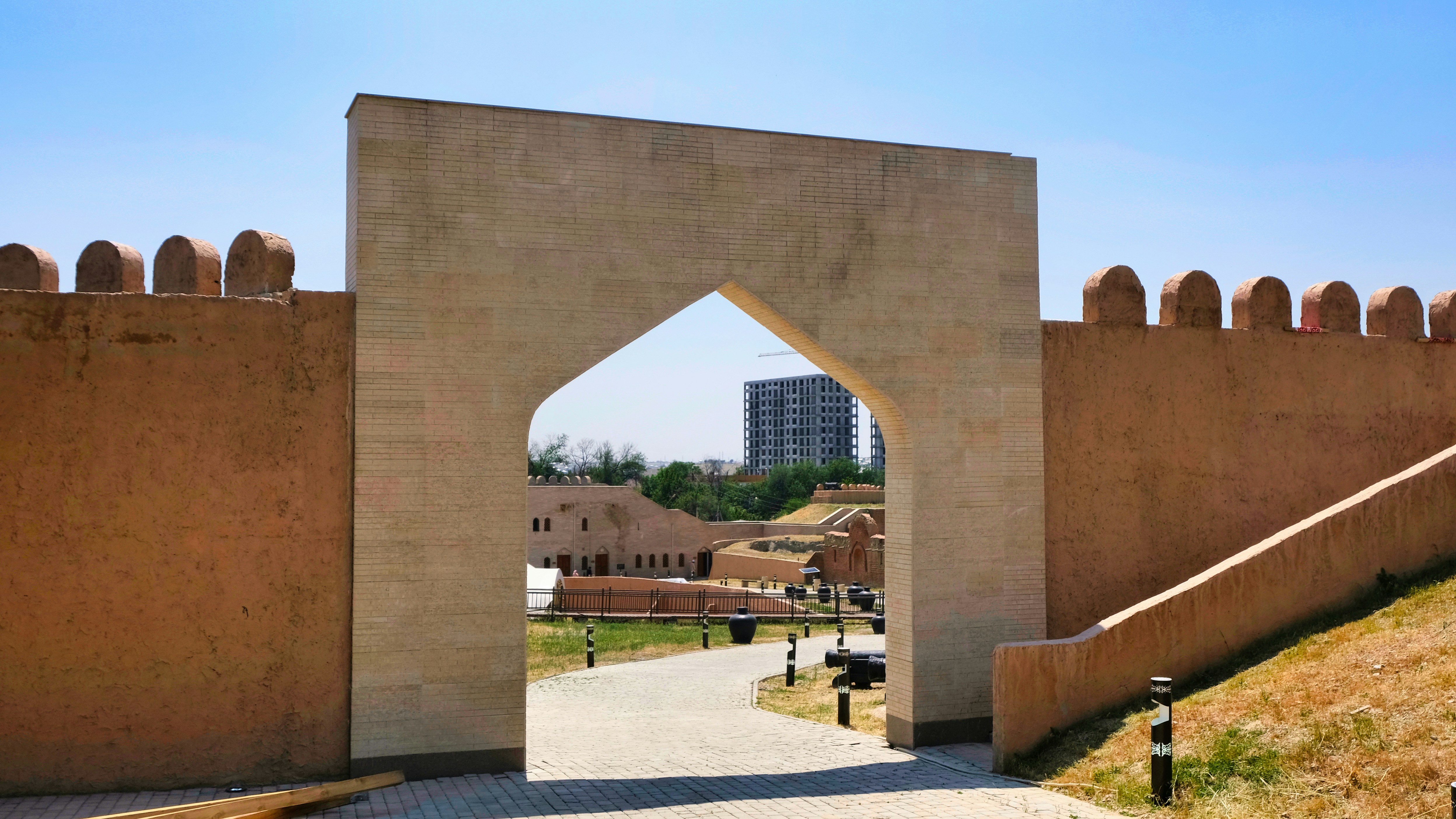 a large stone archway with a building in the background