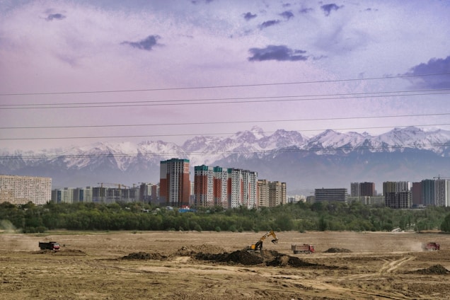 Photo of Almas Al-Aswad team collaborating on a project site with heavy machinery in the background.