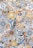 A colorful mosaic pattern composed of various geometric and floral designs. The intricate tiles feature vibrant colors such as blue, yellow, orange, and white, arranged in a patchwork style.