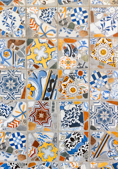 Close-up of a vibrant mosaic floor featuring intricate Mediterranean patterns in warm earth tones.