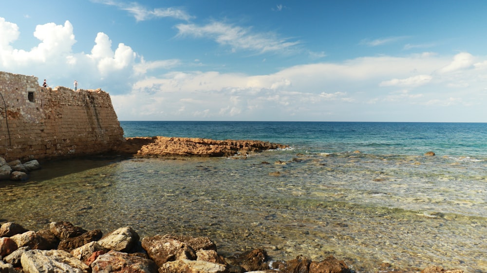 a rocky shore with a body of water