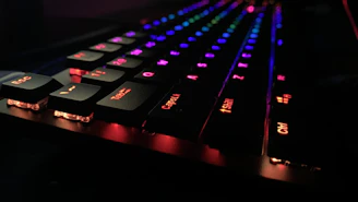 Close-up of a mechanical keyboard with RGB lighting glowing in a dark room