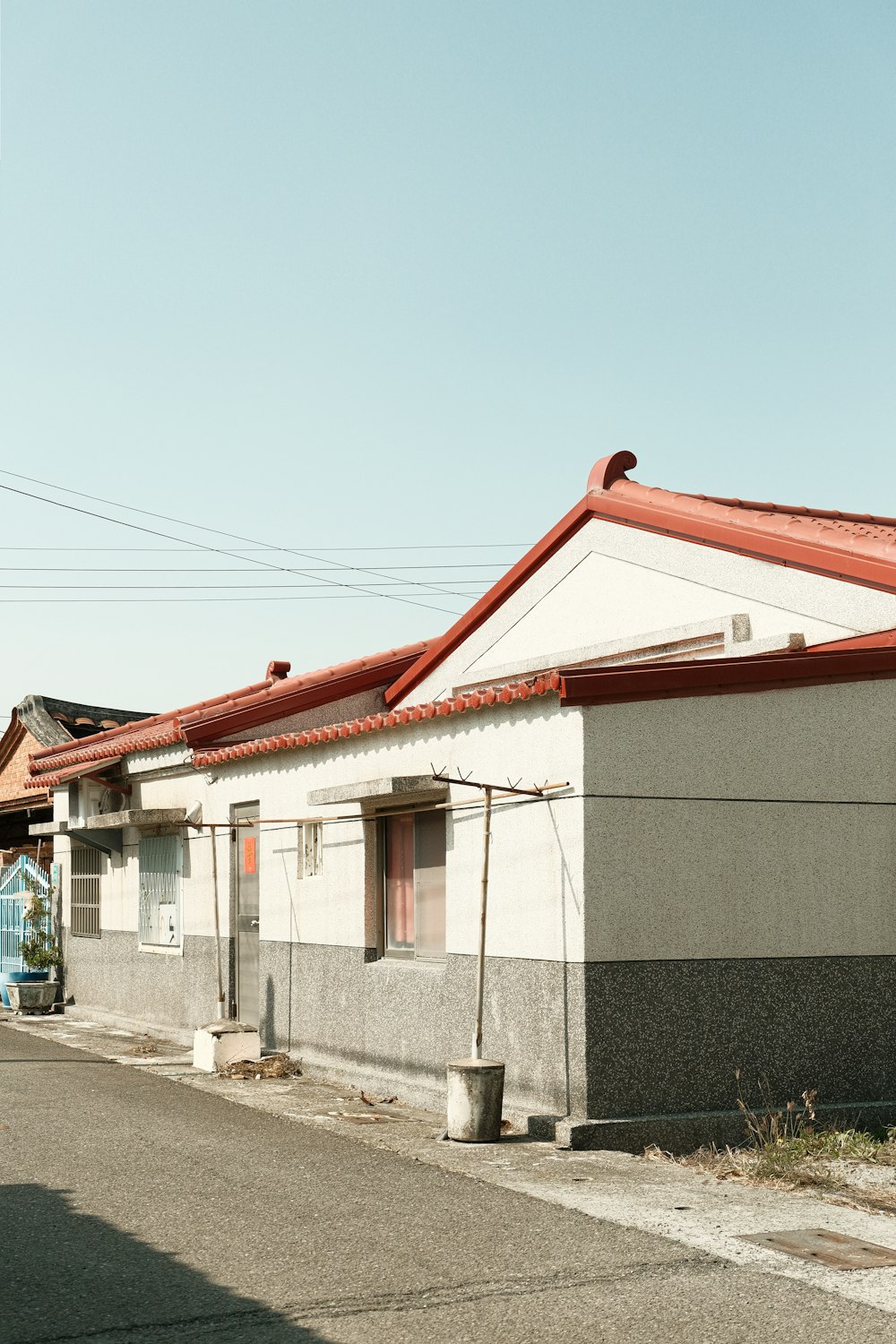 a building with a red roof next to a street