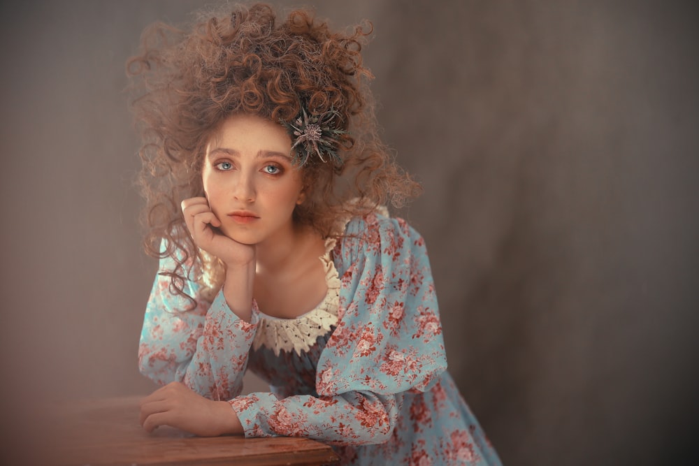 a woman with curly hair sitting at a table