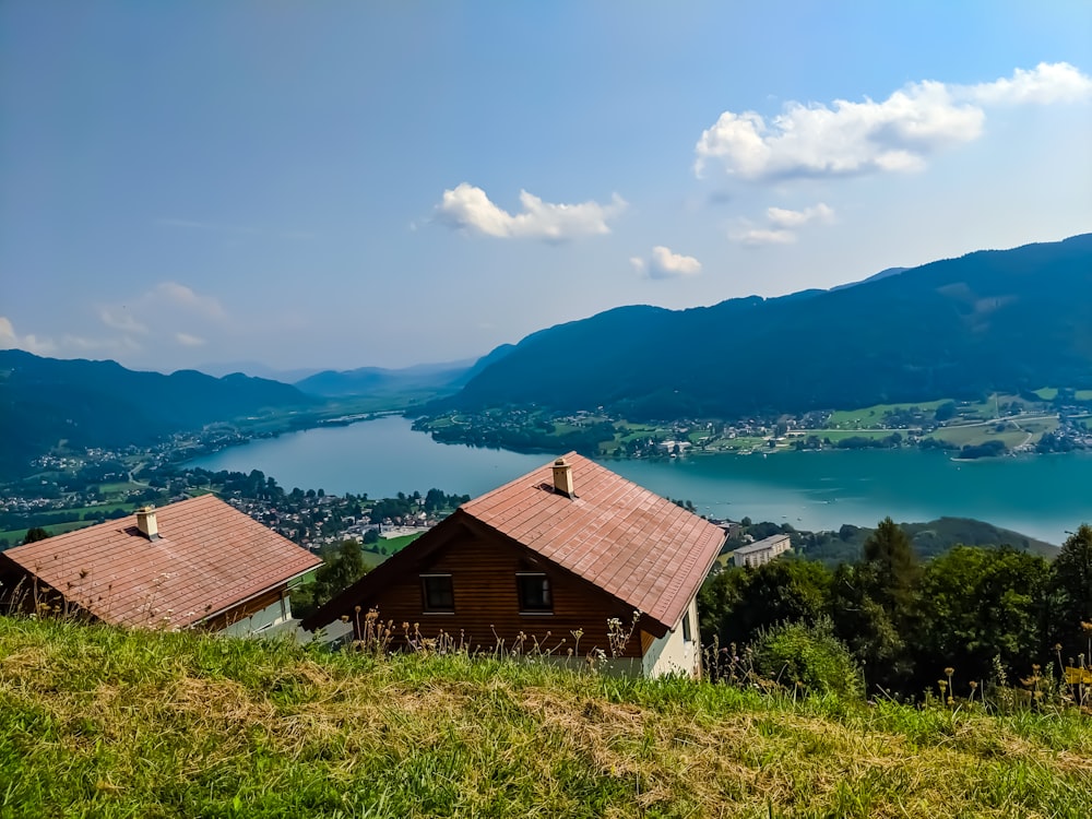 a couple of houses sitting on top of a lush green hillside