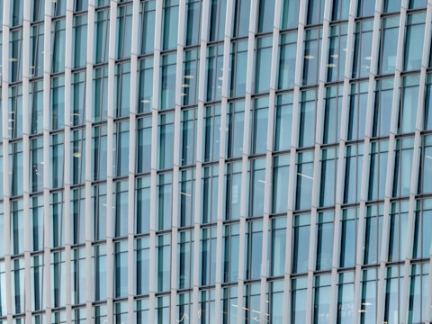 Close-up of workers fitting modern windows and doors into a new building facade.