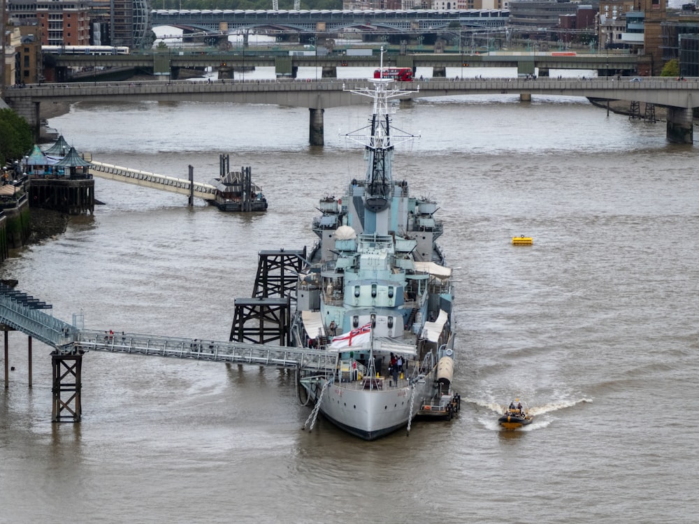 a large boat traveling down a river next to a bridge