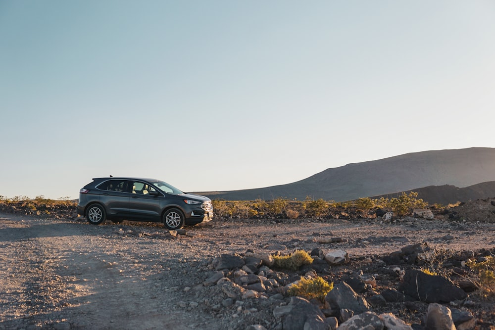 a car is parked in the middle of the desert