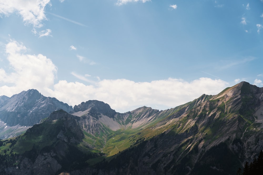 a view of a mountain range from the top of a hill